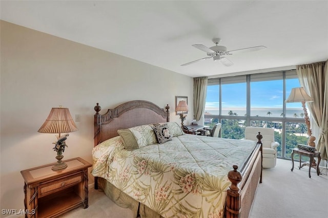 carpeted bedroom with a wall of windows and ceiling fan