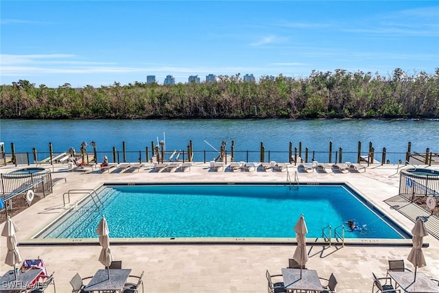 view of swimming pool with a patio and a water view