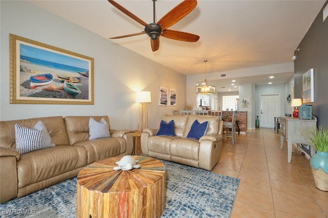 living room with light tile patterned flooring and ceiling fan with notable chandelier