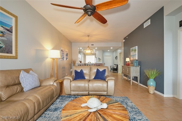 living room featuring light tile patterned floors and ceiling fan with notable chandelier