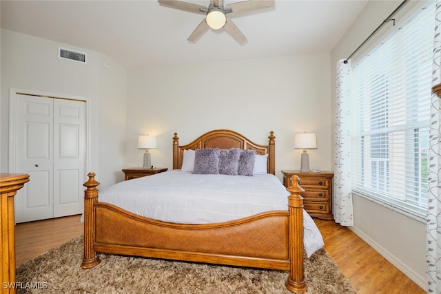 bedroom with ceiling fan, a closet, and light hardwood / wood-style floors