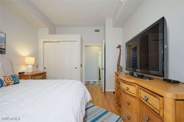 bedroom with a closet and light hardwood / wood-style flooring