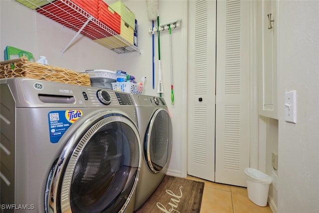 laundry area with light tile patterned floors and washer and dryer