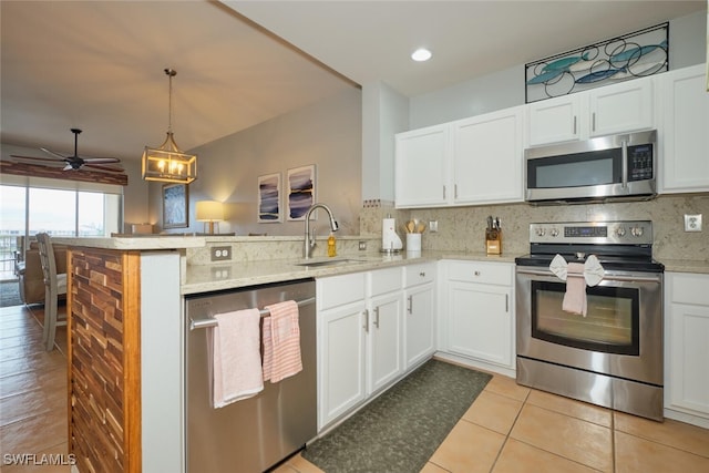 kitchen featuring sink, white cabinets, appliances with stainless steel finishes, and kitchen peninsula