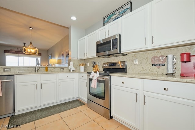 kitchen with pendant lighting, white cabinetry, stainless steel appliances, decorative backsplash, and sink