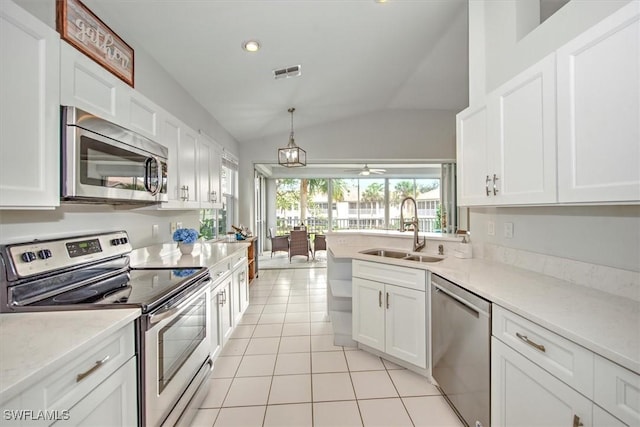 kitchen featuring ceiling fan, stainless steel appliances, vaulted ceiling, white cabinets, and sink