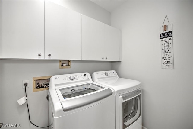 clothes washing area featuring cabinets and independent washer and dryer