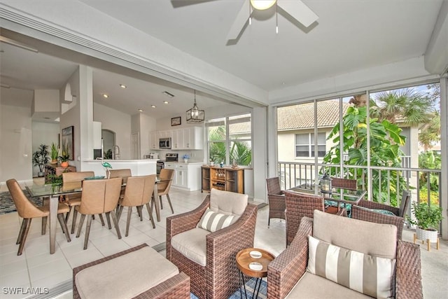 sunroom with ceiling fan with notable chandelier