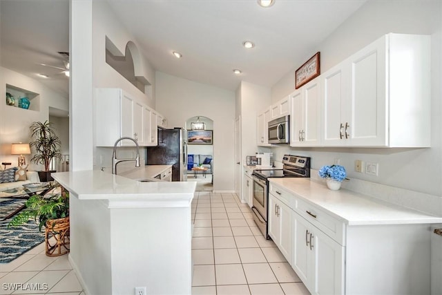 kitchen featuring light tile patterned floors, stainless steel appliances, white cabinets, and kitchen peninsula