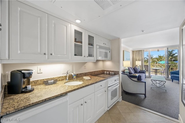 kitchen with white appliances, white cabinets, dark stone countertops, sink, and floor to ceiling windows