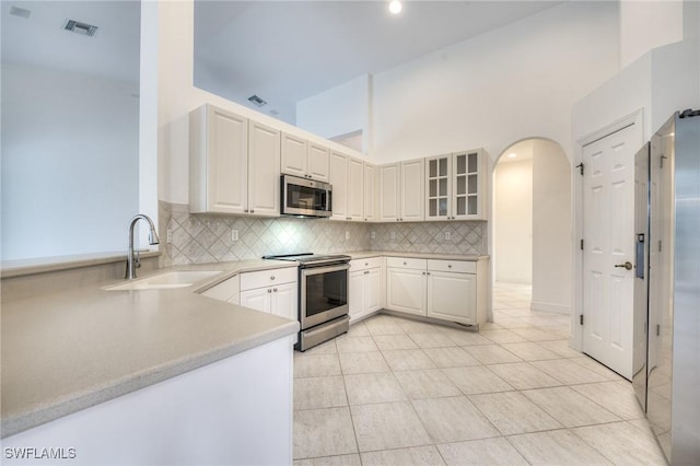 kitchen featuring white cabinetry, appliances with stainless steel finishes, sink, and decorative backsplash