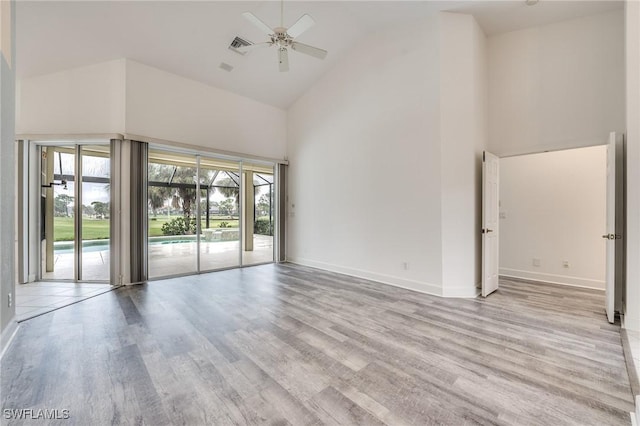 unfurnished room featuring ceiling fan, high vaulted ceiling, and light wood-type flooring