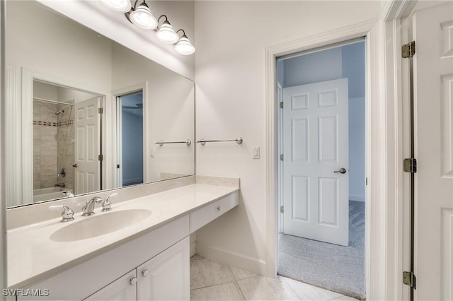 bathroom featuring tile patterned floors, tiled shower / bath combo, and vanity