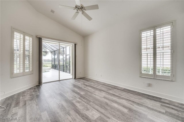 spare room with ceiling fan, vaulted ceiling, and light hardwood / wood-style flooring