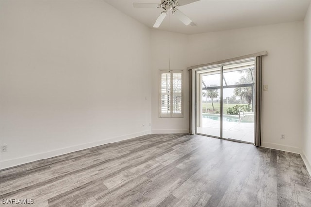 spare room featuring vaulted ceiling, ceiling fan, and light hardwood / wood-style flooring