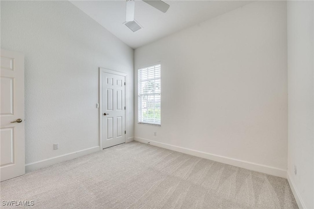 carpeted spare room with lofted ceiling and ceiling fan