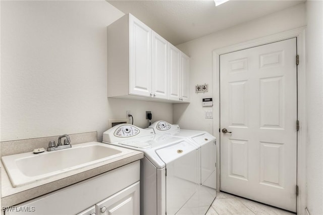 laundry room featuring cabinets, sink, and washing machine and dryer