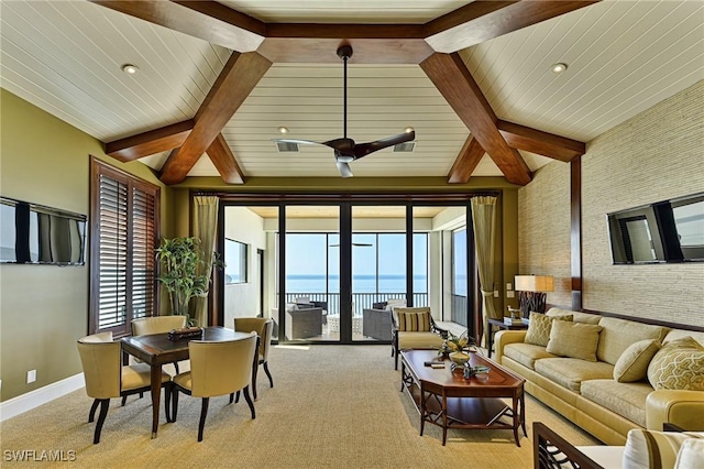 living room featuring a water view, lofted ceiling with beams, and light carpet