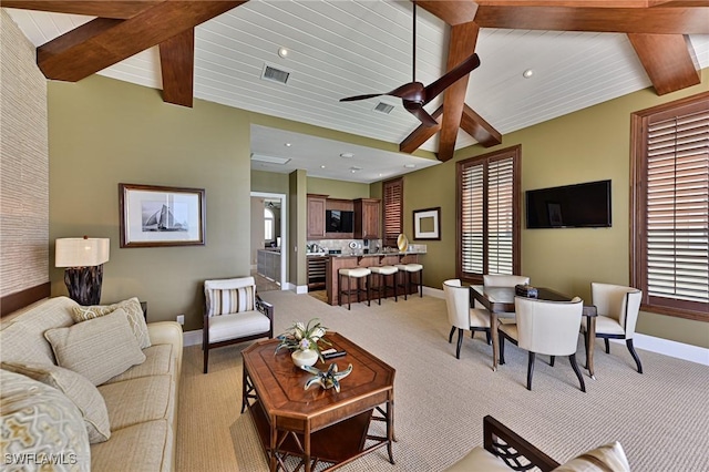 carpeted living room with vaulted ceiling with beams, wood ceiling, a wealth of natural light, and ceiling fan