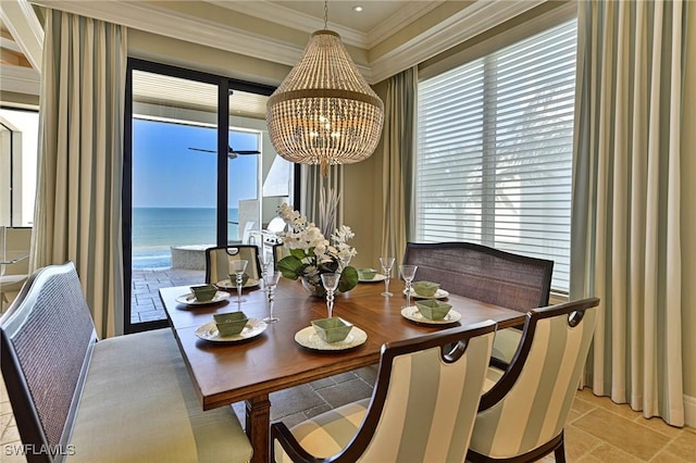 dining area featuring a water view, ornamental molding, and an inviting chandelier