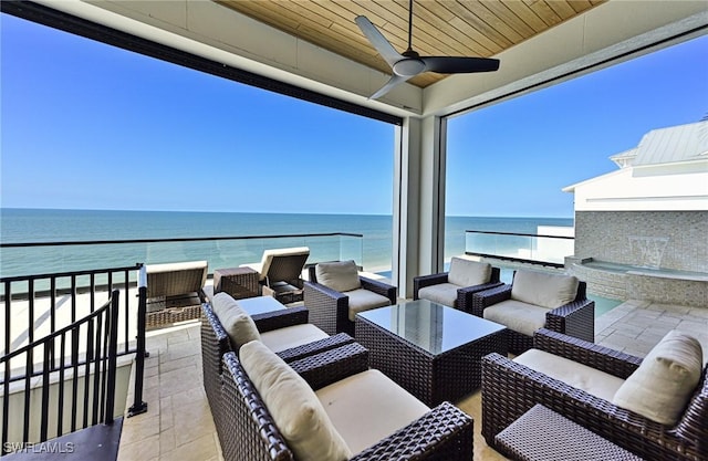 view of patio featuring a beach view, a water view, a balcony, outdoor lounge area, and ceiling fan