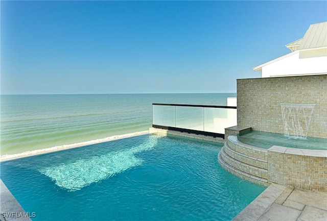 view of swimming pool featuring pool water feature and a water view