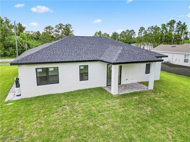 rear view of property with a lawn and a patio area