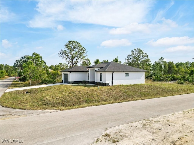 view of front of property with a garage and a front lawn