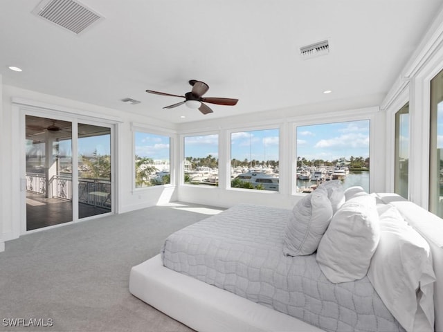 carpeted bedroom with a water view, ceiling fan, and access to outside