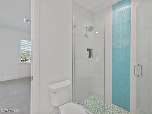 bathroom featuring toilet and a shower with shower door