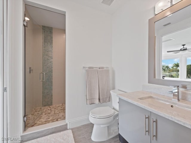 bathroom with a shower with shower door, toilet, tile patterned flooring, vanity, and ceiling fan