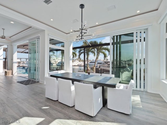 dining room with hardwood / wood-style flooring and ceiling fan with notable chandelier