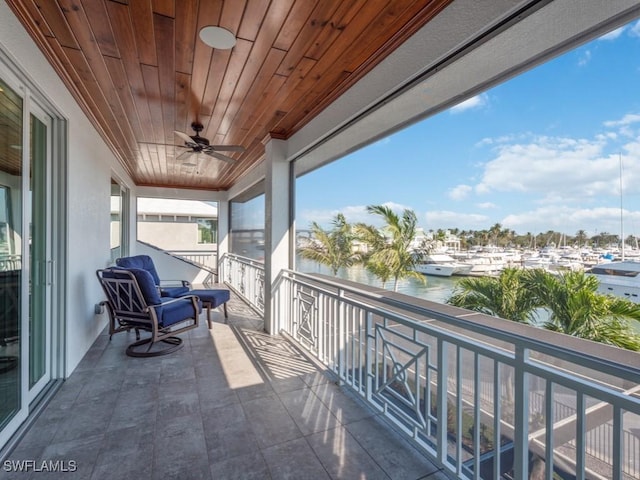 balcony with a water view and ceiling fan