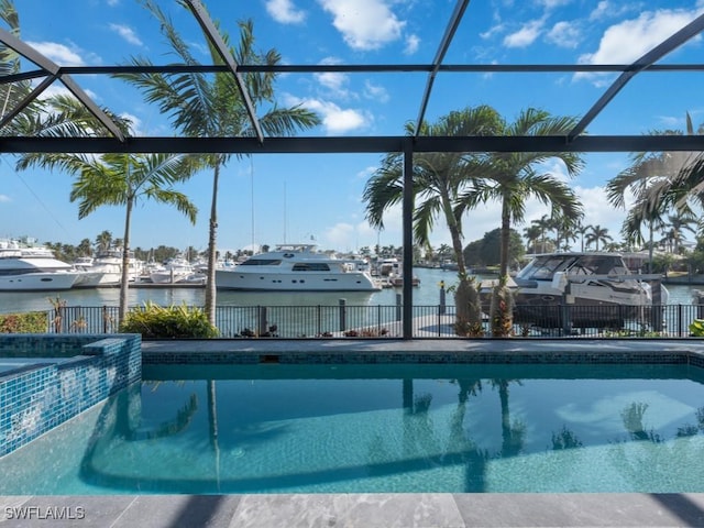 view of swimming pool featuring glass enclosure and a water view