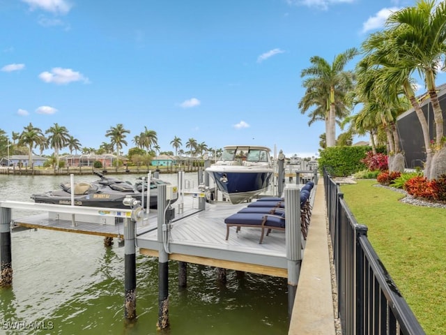 view of dock with a water view and a yard