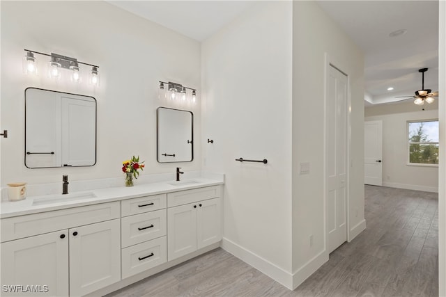 bathroom with hardwood / wood-style flooring, ceiling fan, and vanity