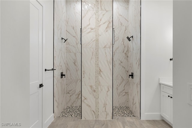 bathroom featuring a tile shower and vanity