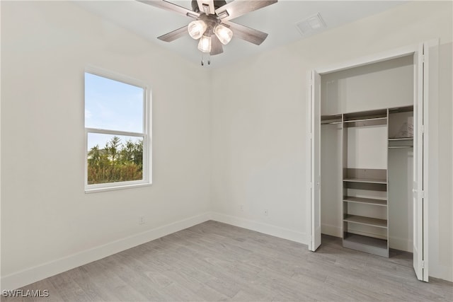 unfurnished bedroom featuring ceiling fan, a closet, and light hardwood / wood-style flooring