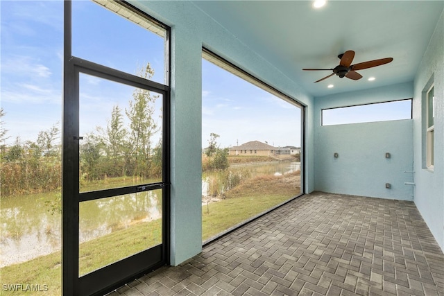 unfurnished sunroom featuring ceiling fan