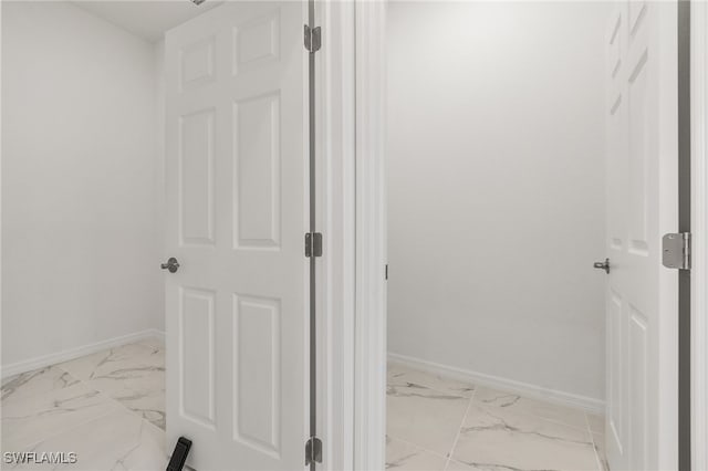 bathroom featuring marble finish floor and baseboards