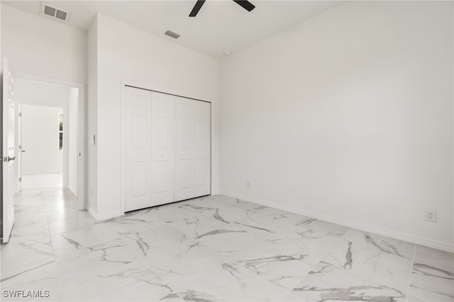 unfurnished bedroom with marble finish floor, visible vents, and a closet