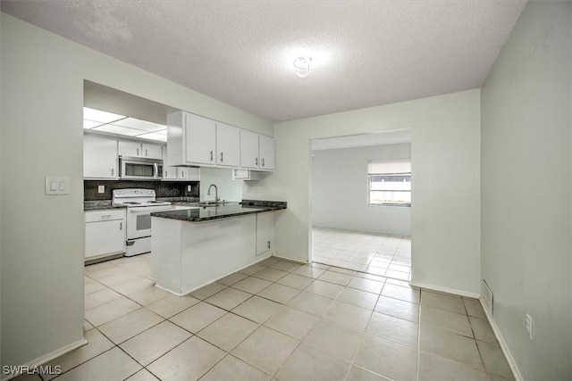 kitchen featuring a textured ceiling, white cabinetry, electric stove, kitchen peninsula, and light tile patterned floors