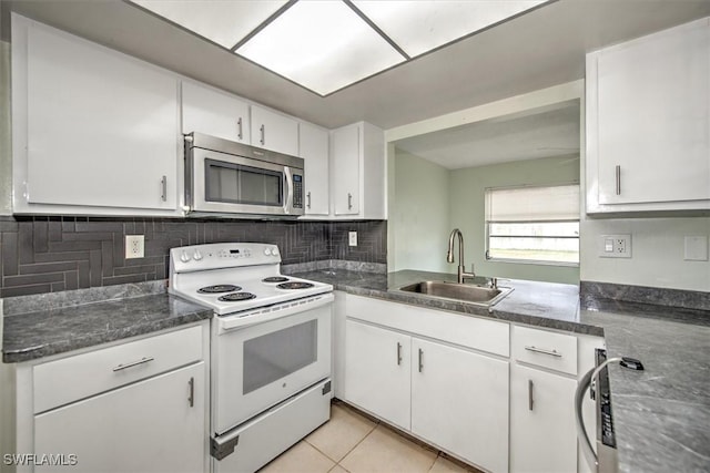 kitchen with light tile patterned floors, white cabinetry, white electric range oven, and sink