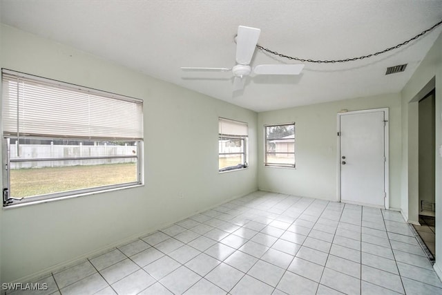 tiled spare room with ceiling fan