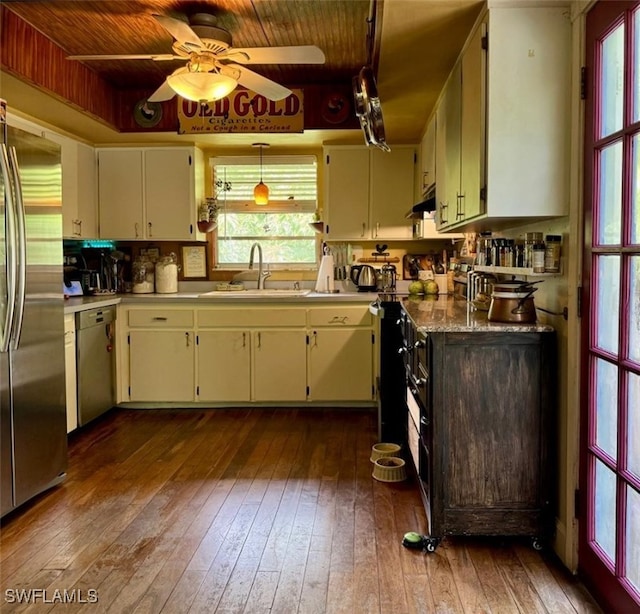 kitchen with sink, dark wood-type flooring, stainless steel appliances, and hanging light fixtures