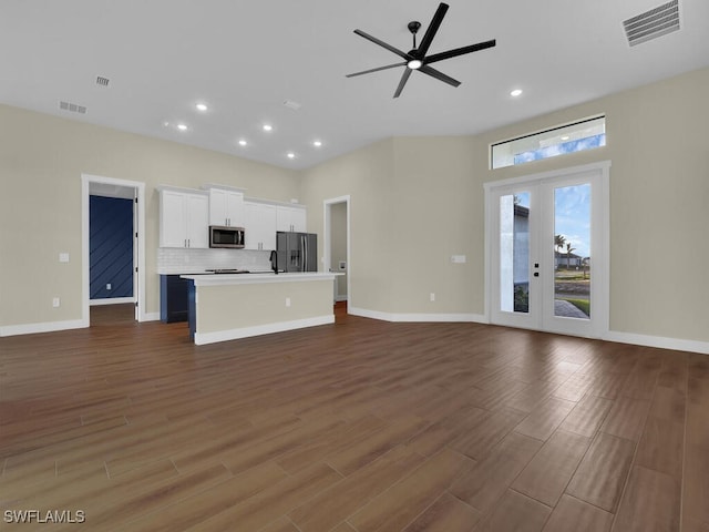 unfurnished living room with dark wood-type flooring, french doors, visible vents, and a ceiling fan