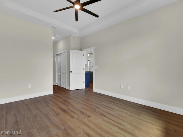 unfurnished room featuring ceiling fan, wood finished floors, visible vents, and baseboards