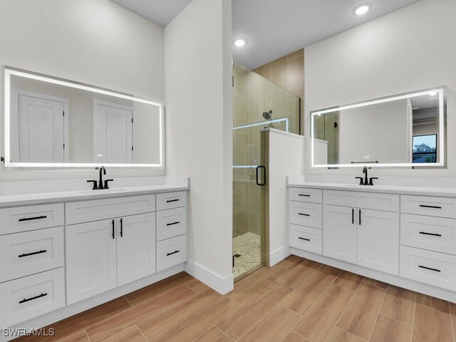 full bathroom with wood finish floors, two vanities, and a sink