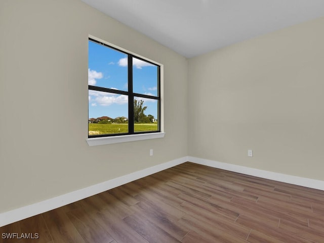 unfurnished room with wood finished floors and baseboards