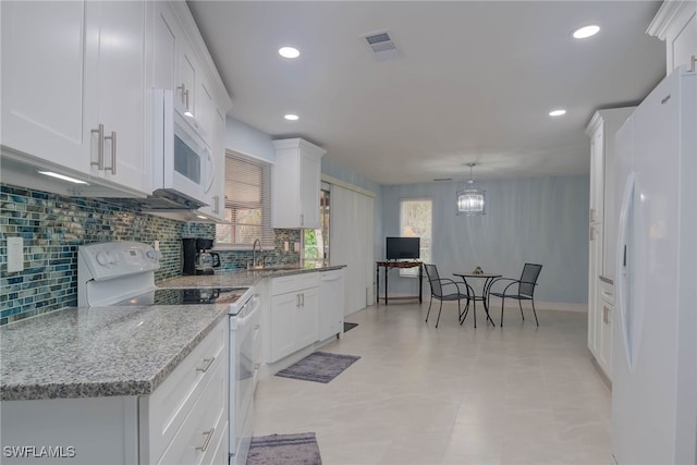 kitchen with backsplash, white appliances, pendant lighting, and white cabinets